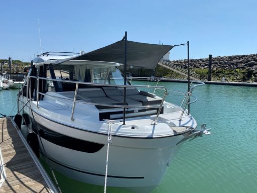 Motorboot im Hafen, mit Sonnenschutz und ruhigem Wasser im Hintergrund.