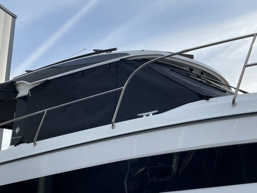 Schwarze Abdeckung auf dem Dach eines Bootes unter blauem Himmel.